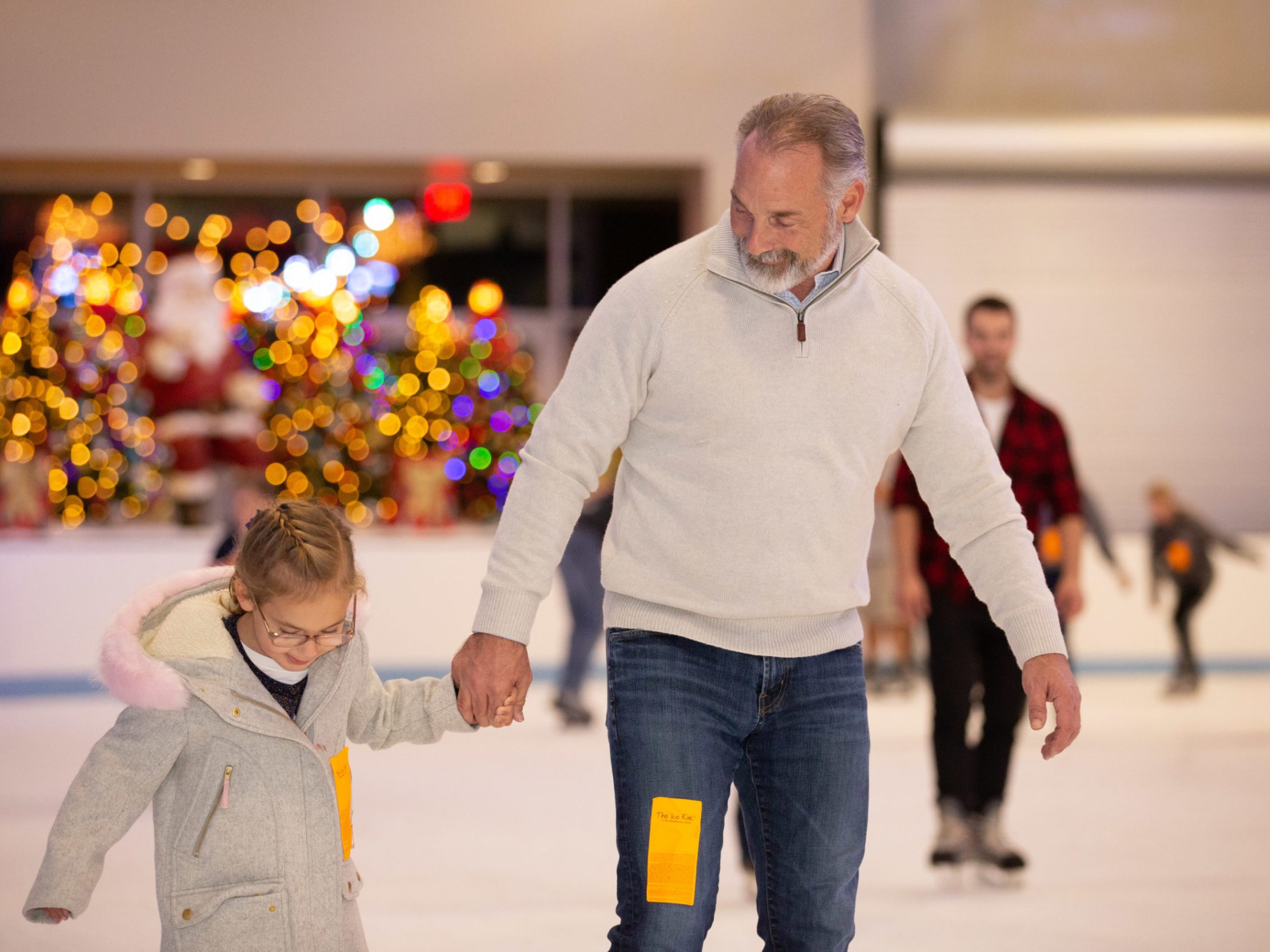 father and daughter ice skating together