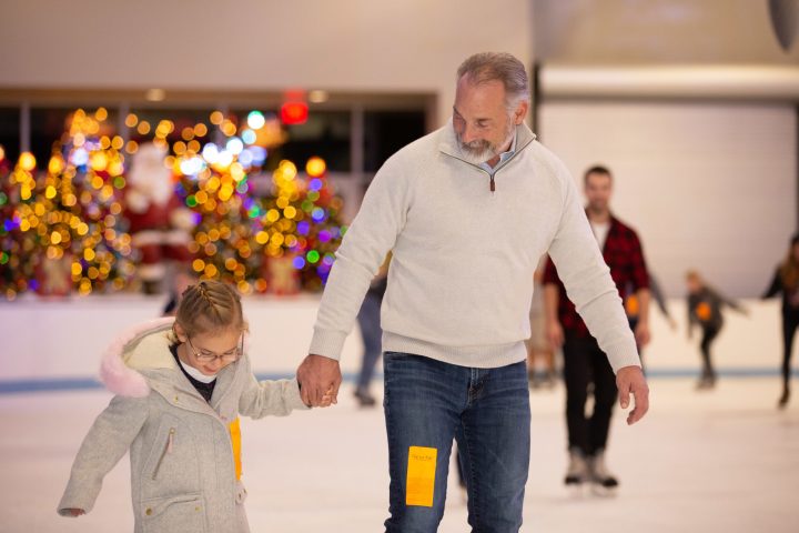 father and daughter ice skating together